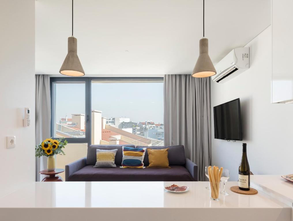 a living room with a couch and a large window at LSA Parque by Numa in Lisbon