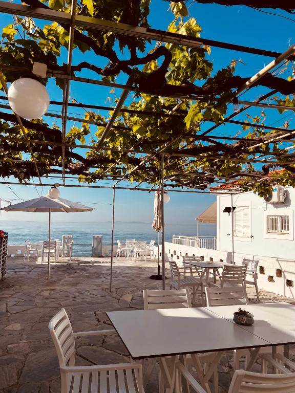 a table and chairs with the ocean in the background at Alkisti's seaside apartments in Pythagoreio