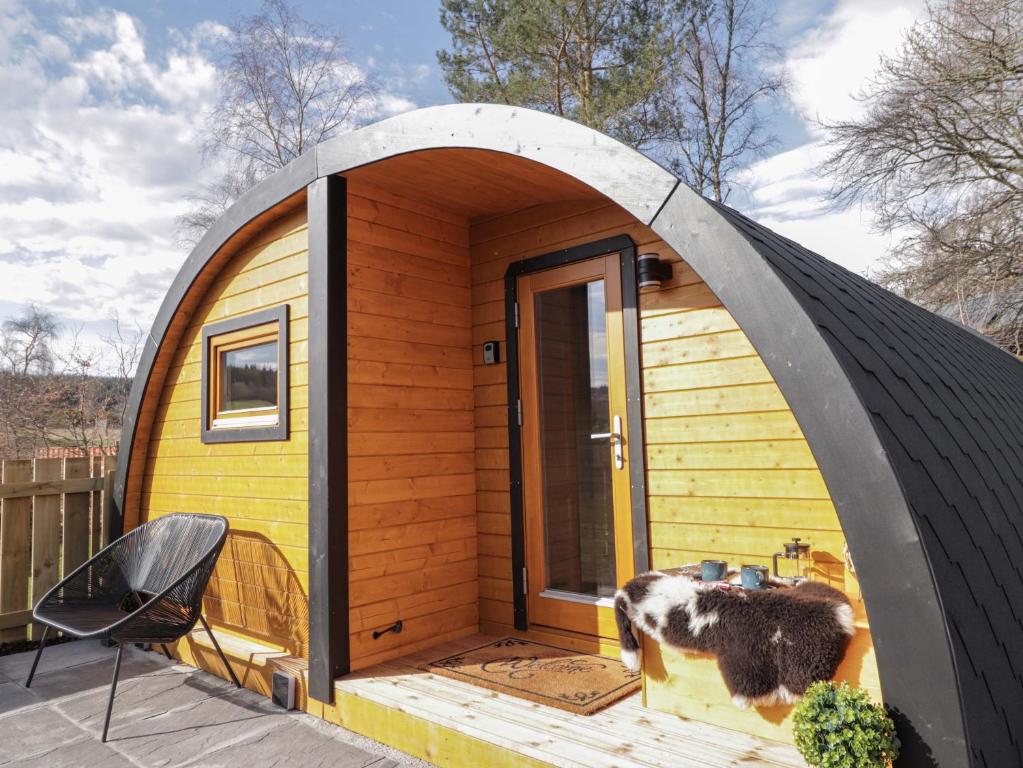 a dome shaped tiny house with a cow standing outside at Little Oaks in Dingwall
