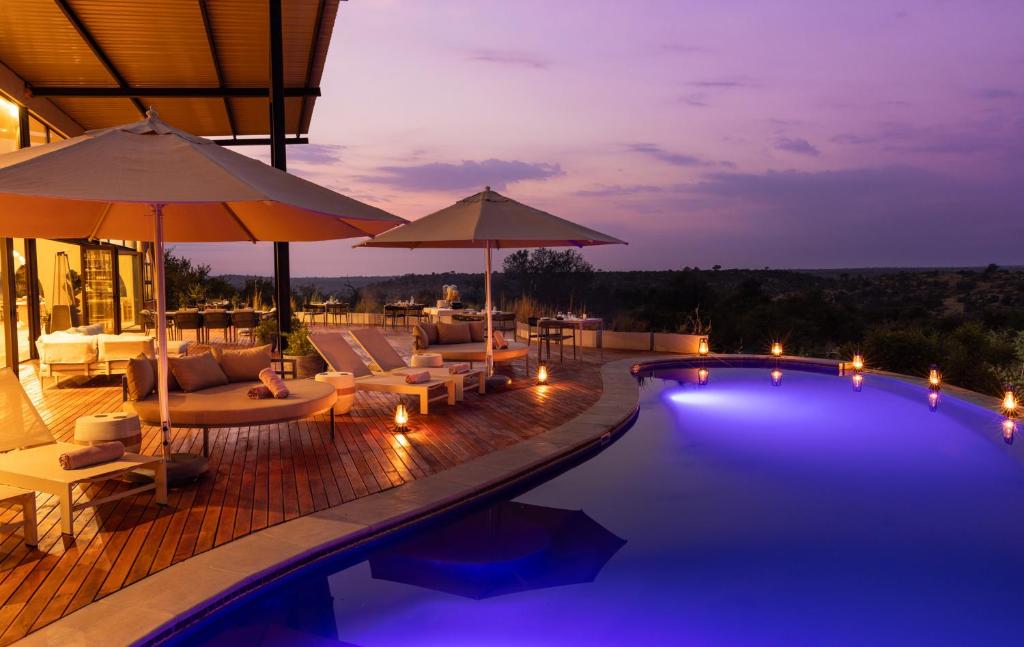 a pool with chairs and umbrellas at night at 18 On The Hill in Mica