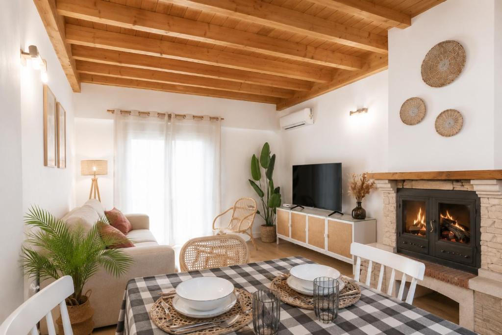 a living room with a table and a fireplace at Duplex El Acebuche in Arroyo Frio