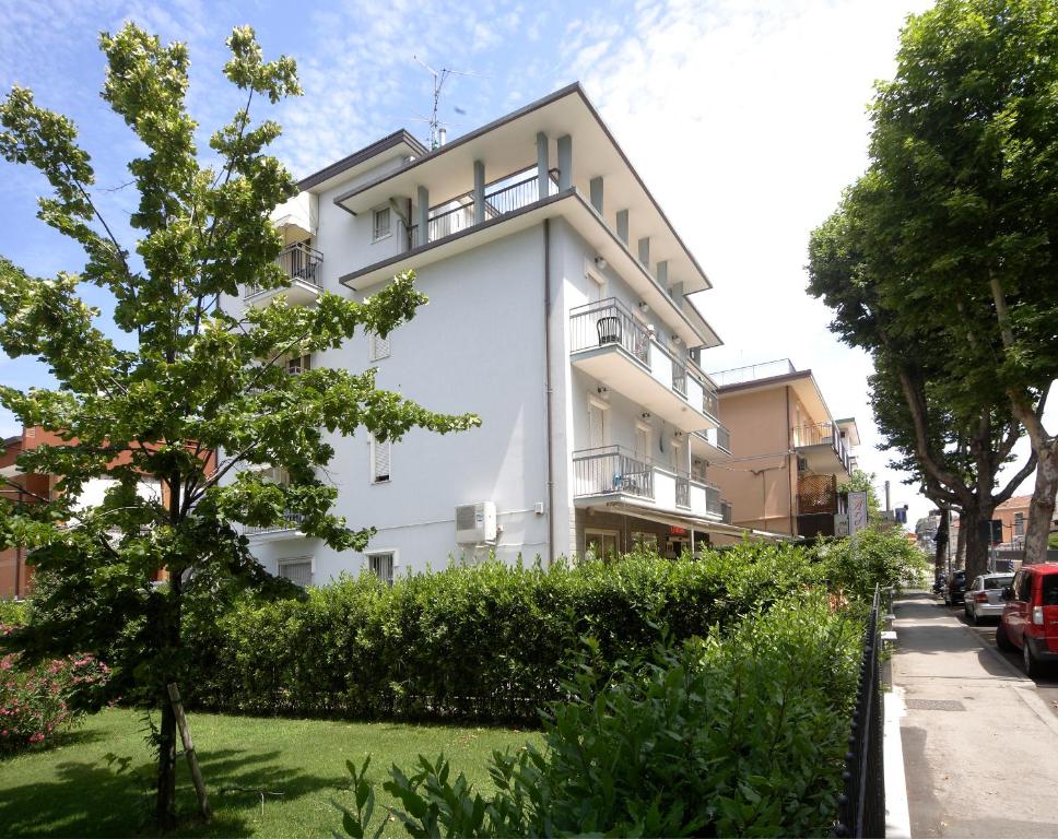 un bâtiment blanc sur le côté d'une rue dans l'établissement Hotel Ardesia, à Rimini