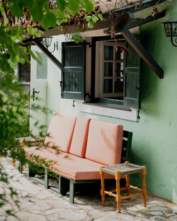 a bench sitting outside of a building with a window at Casa Lucia Green Cottage in Corfu