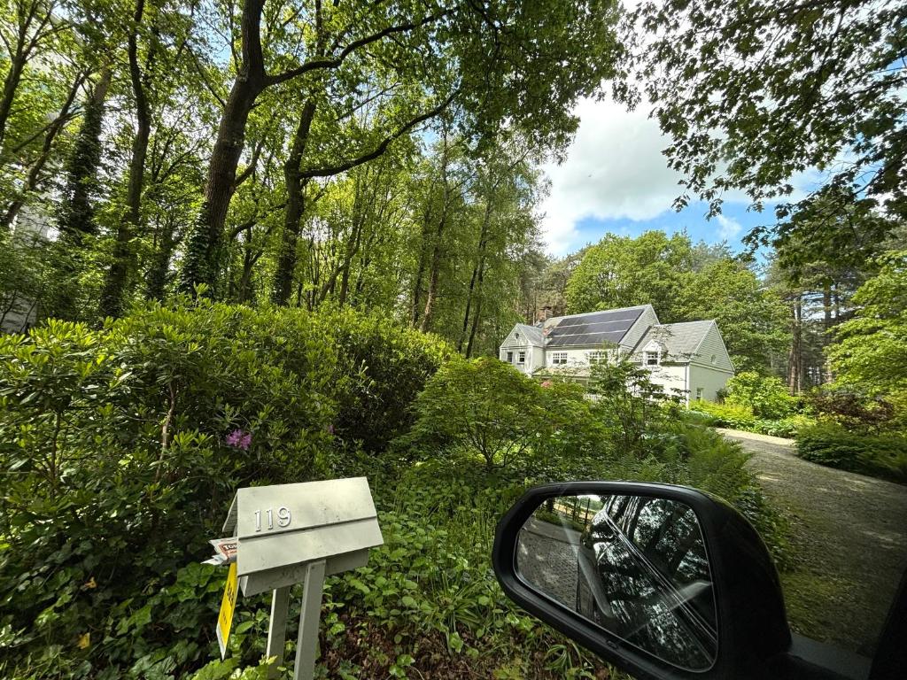 a side view mirror of a car next to a house at A Calm & Quiet Stay in Wuustwezel