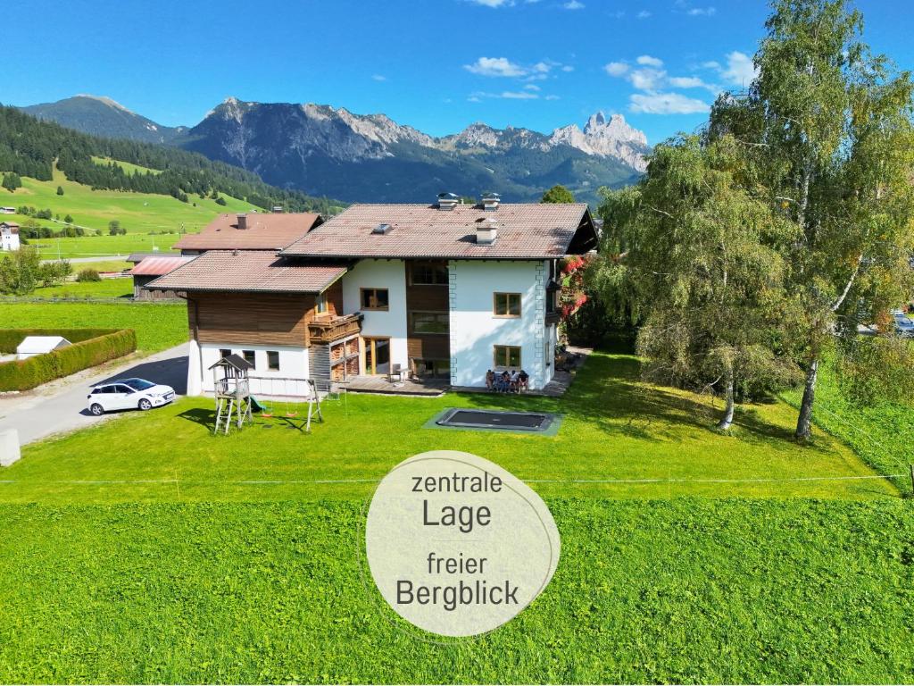 a house in the mountains with a sign in front of it at Apartments Tannheim - Ruhige Apartments mit Infrarotsauna & Sommerbergbahnen inklusive in Tannheim