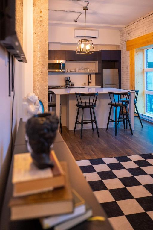 a kitchen with a checkered floor and a kitchen with a table at Les Villas Saint-Roch in Quebec City