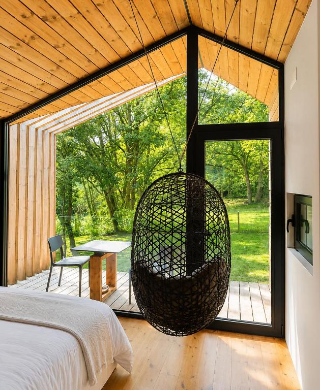 a bedroom with a swing hanging from the ceiling at Cabañas en Ribeira Sacra, Borbela de Luz in Villar de Ordelles