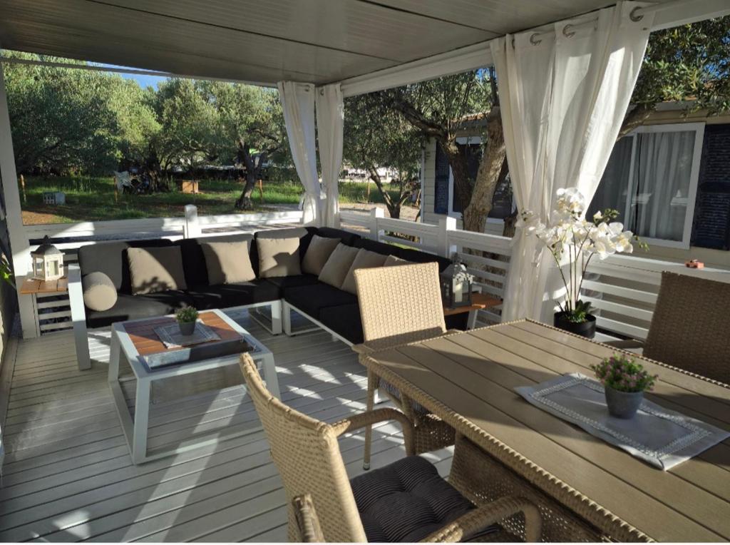 a screened in porch with a couch and a table at Mobile home San Antonio in Sveti Filip i Jakov