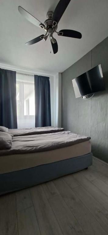 a bedroom with a bed with a ceiling fan at FORT BLIZNE NOCLEGI - superior, standard & basic rooms in Blizne Łaszczyńskiego