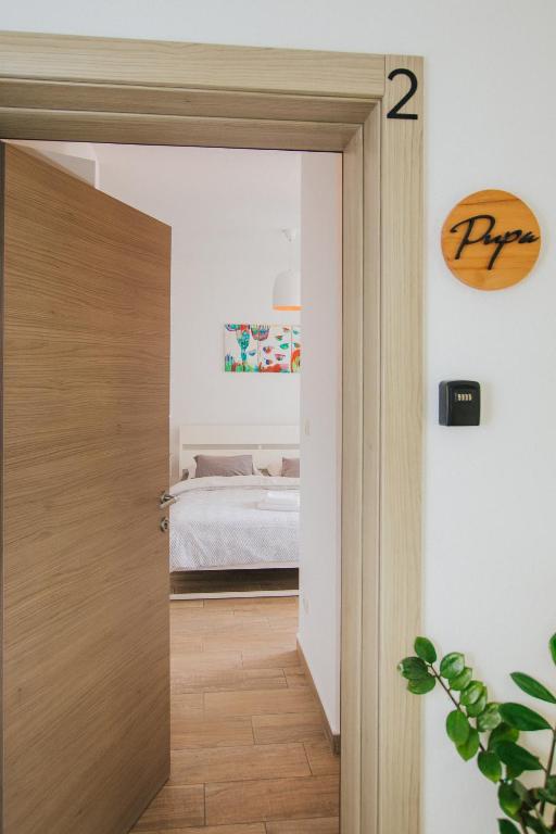a door leading into a bedroom with a bed at Narancin Apartments in Trogir