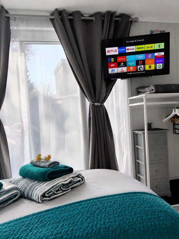 a bedroom with a bed with a flat screen tv at Garden Guesthouse, Sleep4, Private Entrance, Parking, Wifi, AirCon, Derby City in Derby
