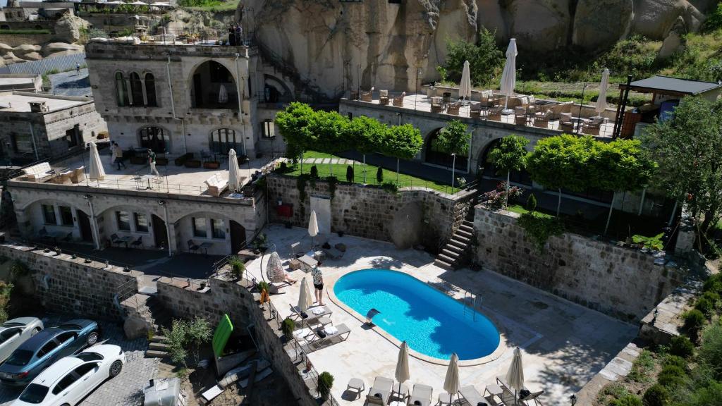 an aerial view of a building with a swimming pool at Cappadocia Secret Hill Cave Suites in Göreme