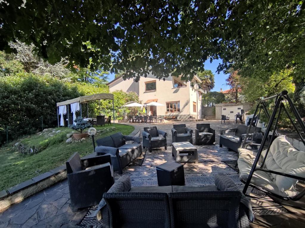 a group of couches sitting in a yard under a tree at Villa Maddalena Brianza in Lentate sul Seveso