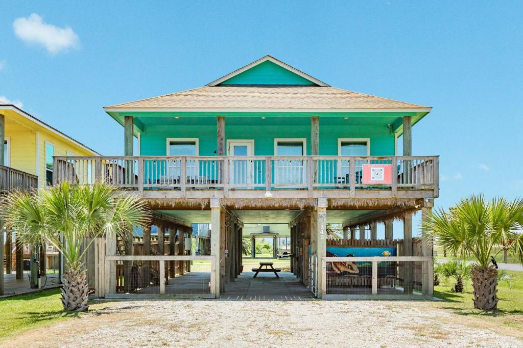 a house with a large deck on the beach at Steps from the Jetty & Beach in Surfside Beach