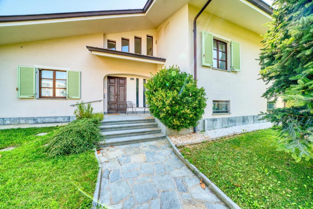 a house with green shutters and a walkway at Villa dante in Alba