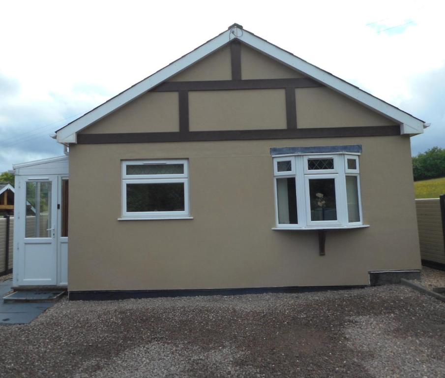 a small house with a window and a door at Dripshill Lodge in Severn Stoke