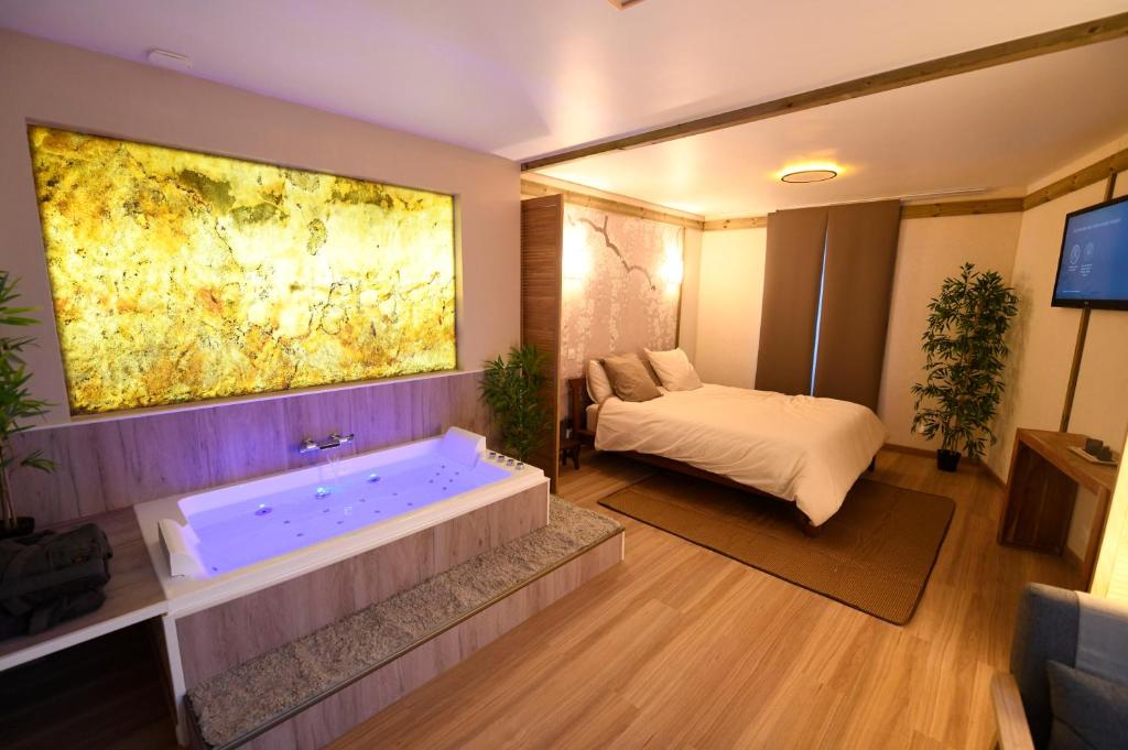 a room with a bath tub with a bed in it at Le Lotus Suite romantique avec SPA privé in Conflans-Sainte-Honorine