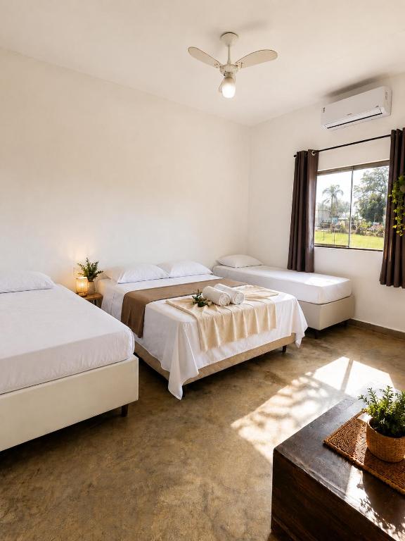 a bedroom with two beds and a window at Pousada Serra do Encanto in Delfinópolis