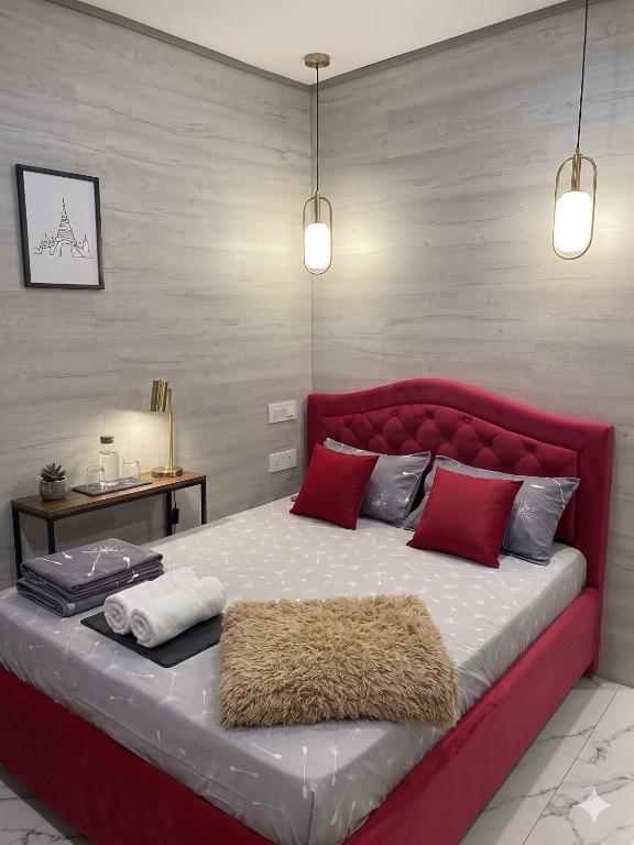 a large bed with a red headboard in a room at Ismail 94-1 Apartments in Chişinău