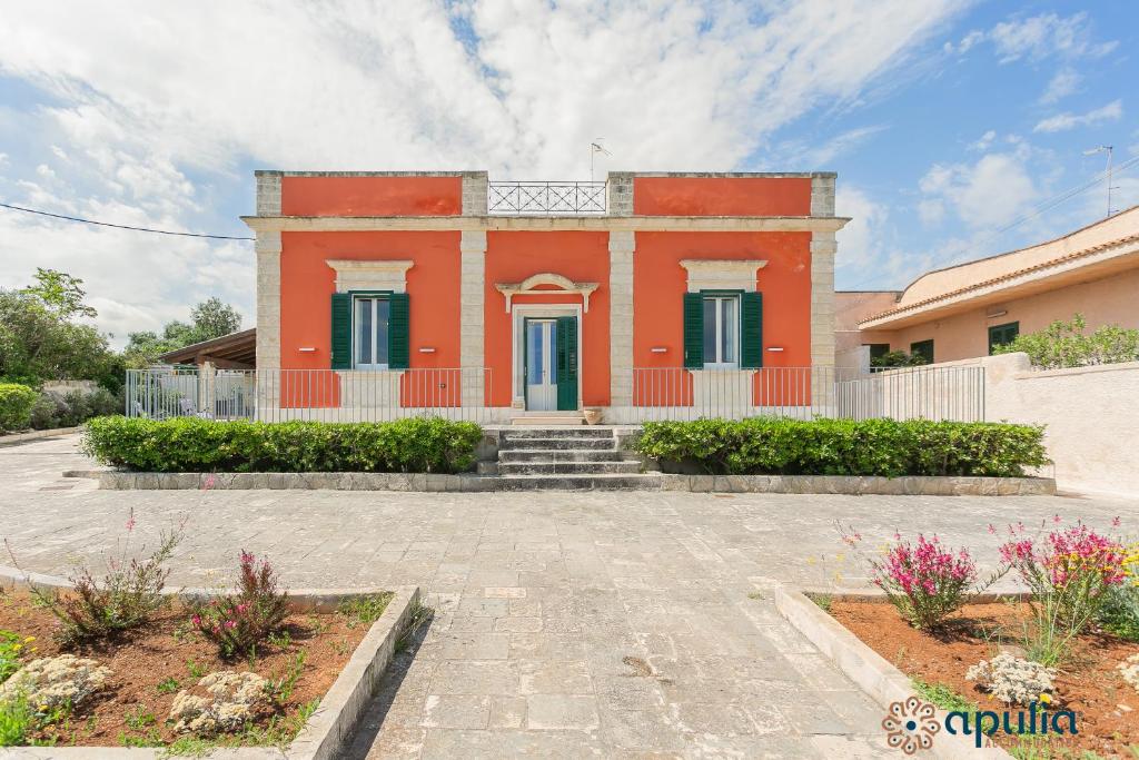 a red house with stairs in front of it at Villa Stone and Sea Escape by Apulia Accommodation in Cozze