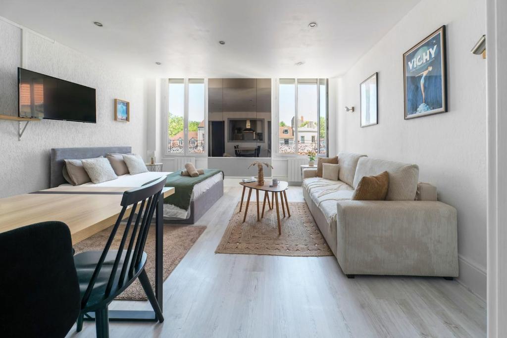 a living room with a couch and a table at Appartement Standing proche des Thermes in Vichy