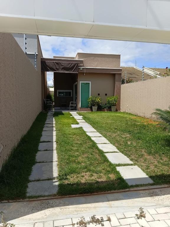 a house with a walkway in front of a yard at Casa Melcon in Aquiraz
