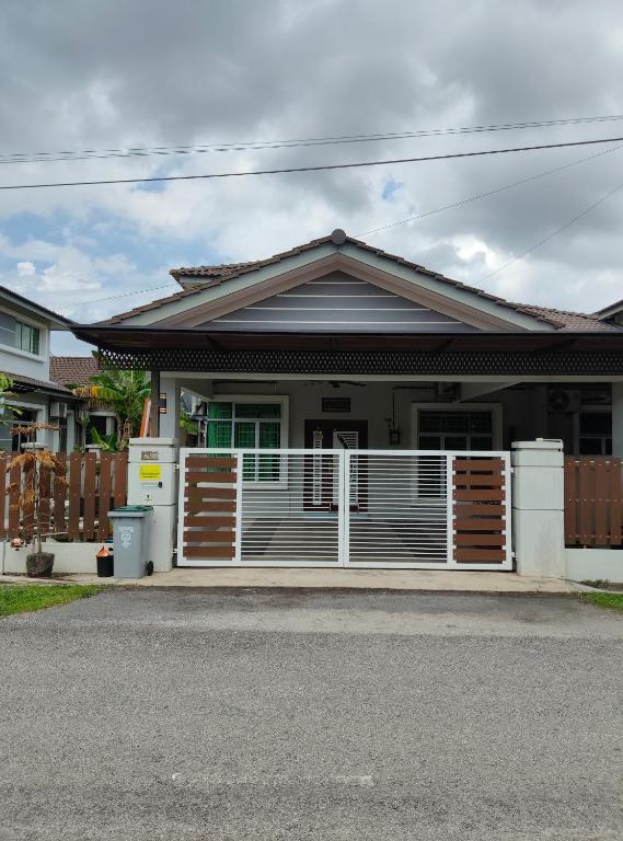 a house with a white fence in front of it at NovaStay Melaka in Kampong Kerubong