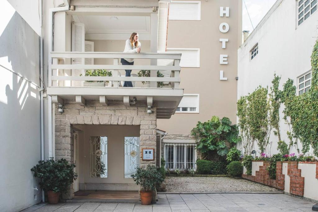 a woman standing on the balcony of a building at Hotel Selent in Mar del Plata