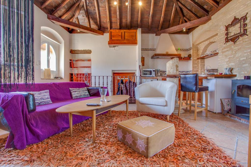 サンルーカル・デ・バラメダにあるAtico Sanlucarの紫色のソファとテーブル付きのリビングルーム