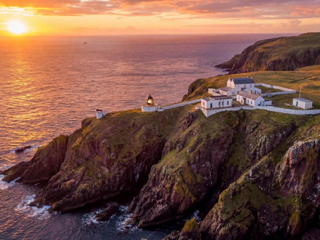 a house on a cliff near the ocean at sunset at Lightkeepers Fold in Eyemouth