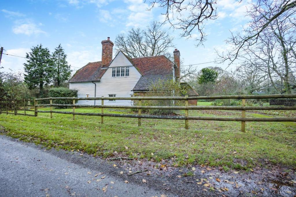 a wooden fence in front of a white house at 2 Bed in Woodchurch oc-b30323 in Woodchurch