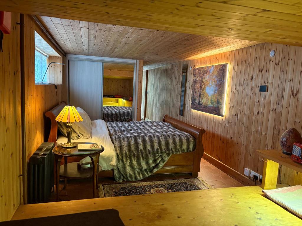 a bedroom with a bed and a lamp on a table at Sanctuary Apartment nestled in nature in Westport
