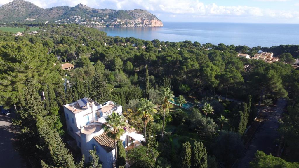 una vista aérea de una casa con árboles y el océano en Can Bellet, suspiros ibicencos, en Canyamel