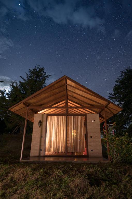 a small building with a roof at night at Las Cabañas La Libertad in Macanal