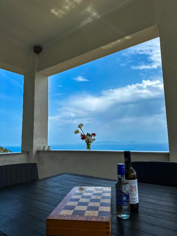 a table with a view of the ocean from a window at Infinite Blue Maisonette with Panoramic Terrace in Ámpelos