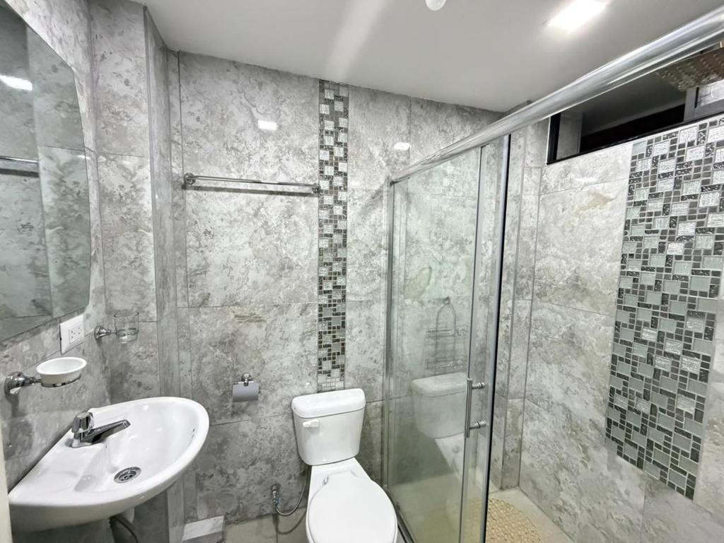 a bathroom with a toilet and a sink and a shower at Hostal Atlantis Middle World in Quito