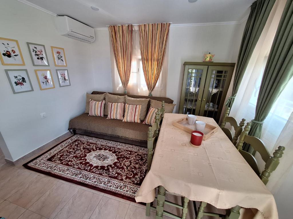 a living room with a table and a couch at Chios Flower House in Agia Ermioni