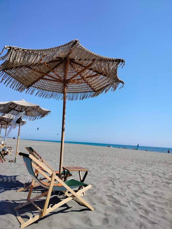 a chair and an umbrella on the beach at Sabina Olive bungalow in Ulcinj