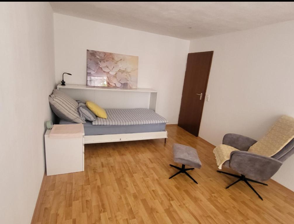 a room with a bed and two chairs in it at Tolle Stadtwohnung in Darmstadt