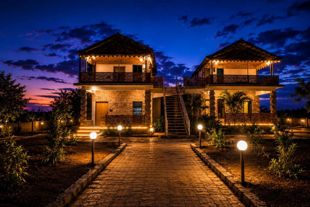 a house with lights on a cobblestone street at The Wilds Villa Gir Jungle Stay with Swimming Pool in Sasan Gir