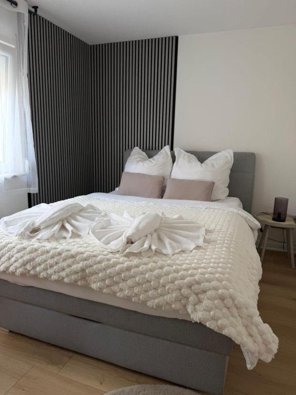 a bedroom with a bed with white sheets and pillows at Zimmer-Enjoy in Altenahr