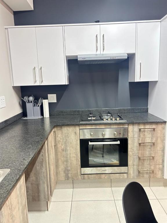 a kitchen with white cabinets and a stove at Elisa's Haven in Matsulu