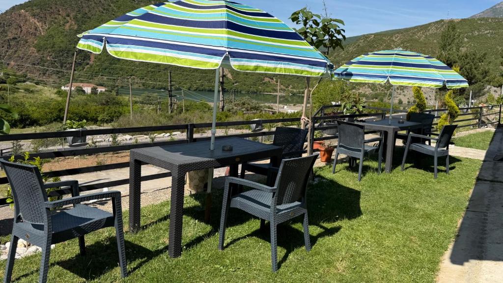 a group of tables and chairs with umbrellas at Xhoen guesthouse in Shkodër