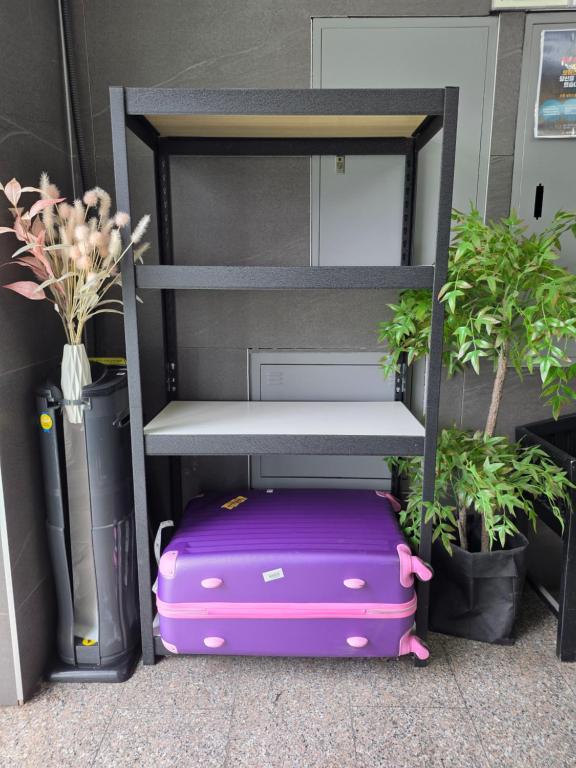 a purple suitcase is sitting next to a chair at Hotel INSAENG Bucheon in Bucheon