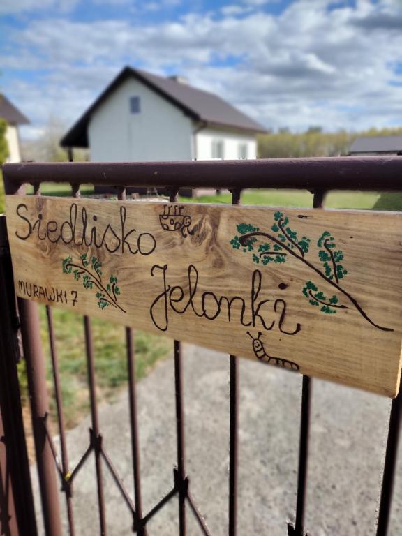 a wooden sign on a fence with signatures on it at Siedlisko Jelonki in Urowo
