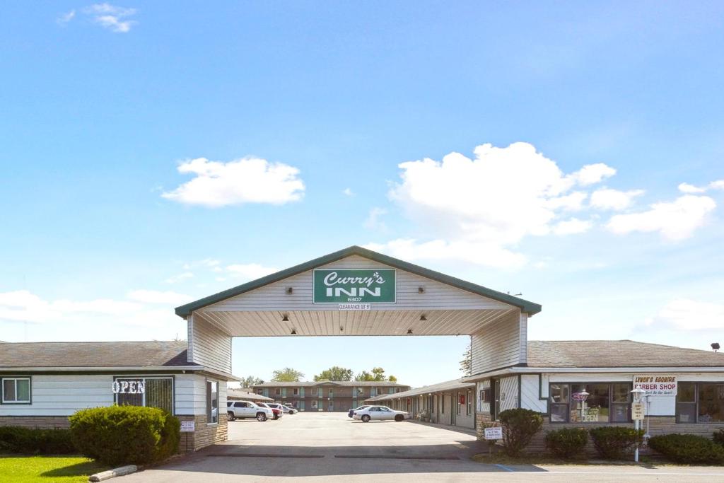 a building with a sign on the top of it at Currys Motel by OYO Saginaw MI in Saginaw