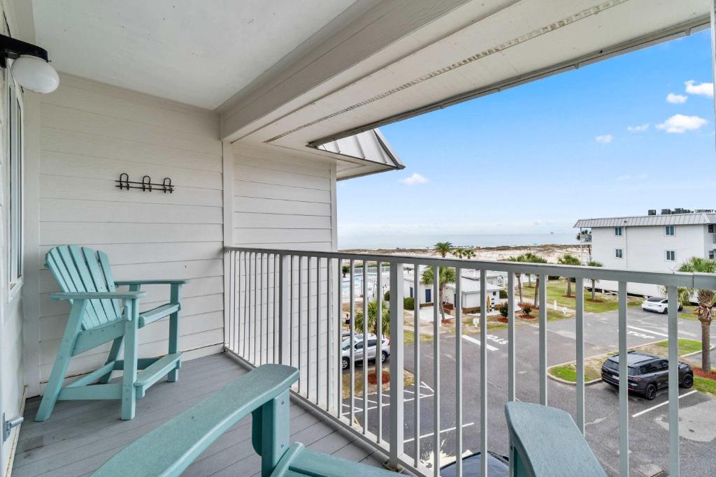 a balcony with a blue chair and a view of a parking lot at Plantation East #2310 in Gulf Highlands