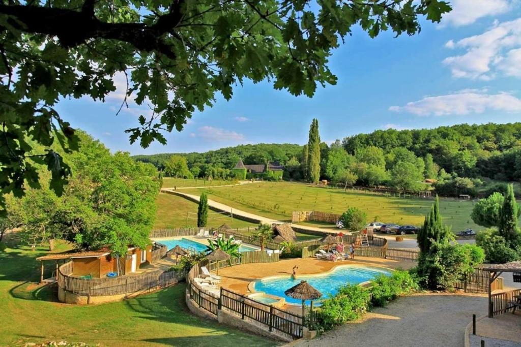 a resort with a swimming pool in a park at Camping 3 étoiles - Piscine - ccbfh0d in Saint-Amand-de-Coly