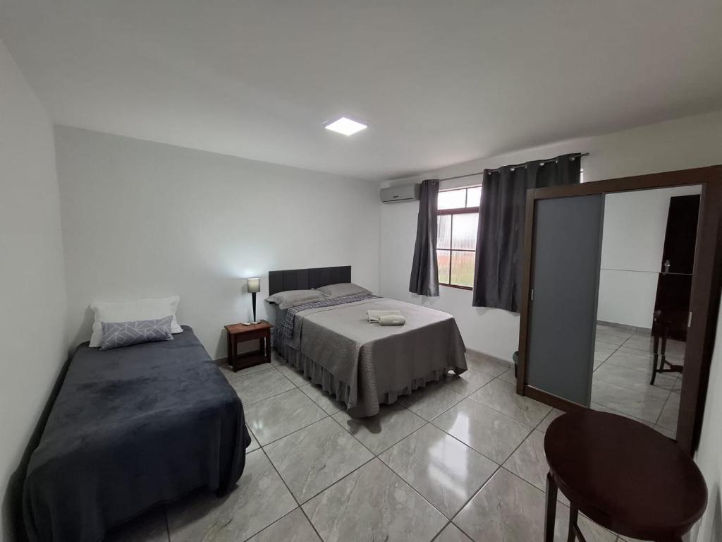 a bedroom with a bed and a mirror in it at Confortável & Bem Localizado! in Campo Grande
