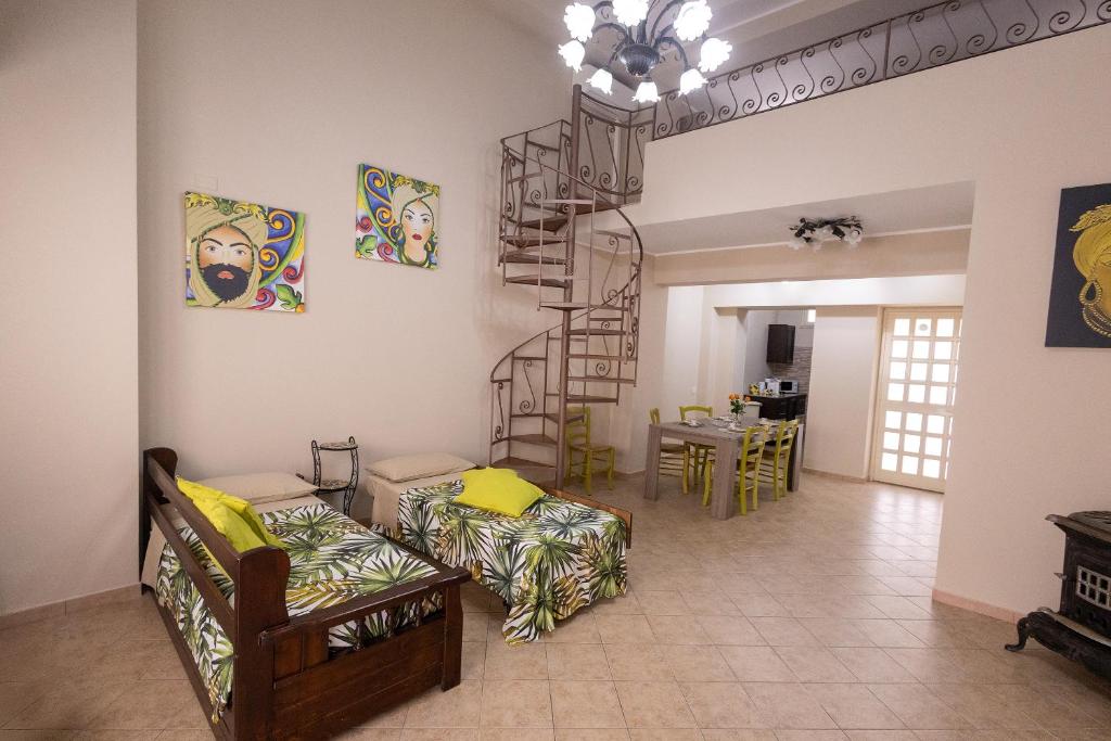 a living room with couches and a spiral staircase at Ciccio's House in Giardini Naxos